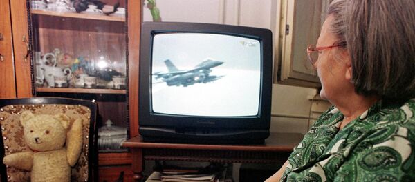 An unidentified Bosnian woman watches NATO air strikes against Yugoslav military targets on a TV screen in Tuzla, Bosnia, on Wednesday night, March 25, 1999. An unidentified Bosnian woman watches NATO air strikes against Yugoslav military targets on a TV screen in Tuzla, Bosnia, on Wednesday night, March 25, 1999. - Sputnik Србија
