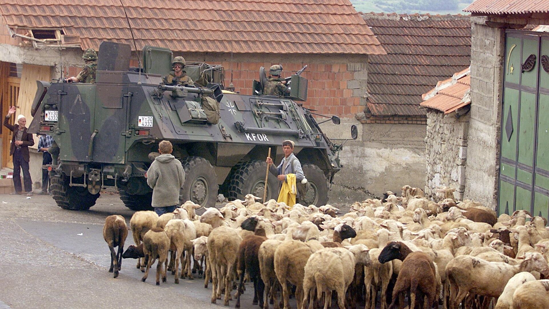 A German armoured vehicle part of the NATO-led KFOR troops drives past a herd of sheep 17 June 1999 in Orahovac, south western Kosovo. - Sputnik Србија, 1920, 02.02.2022