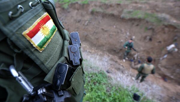 Курдски војник са нашивеном заставом, који се у Ираку бори против џихадиста Исламске државе - Sputnik Србија