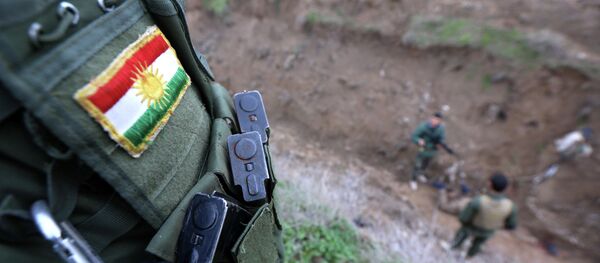 Курдски војник са нашивеном заставом, који се у Ираку бори против џихадиста Исламске државе - Sputnik Србија